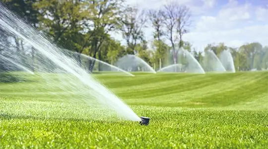Rotating sprinklers watering large commercial field